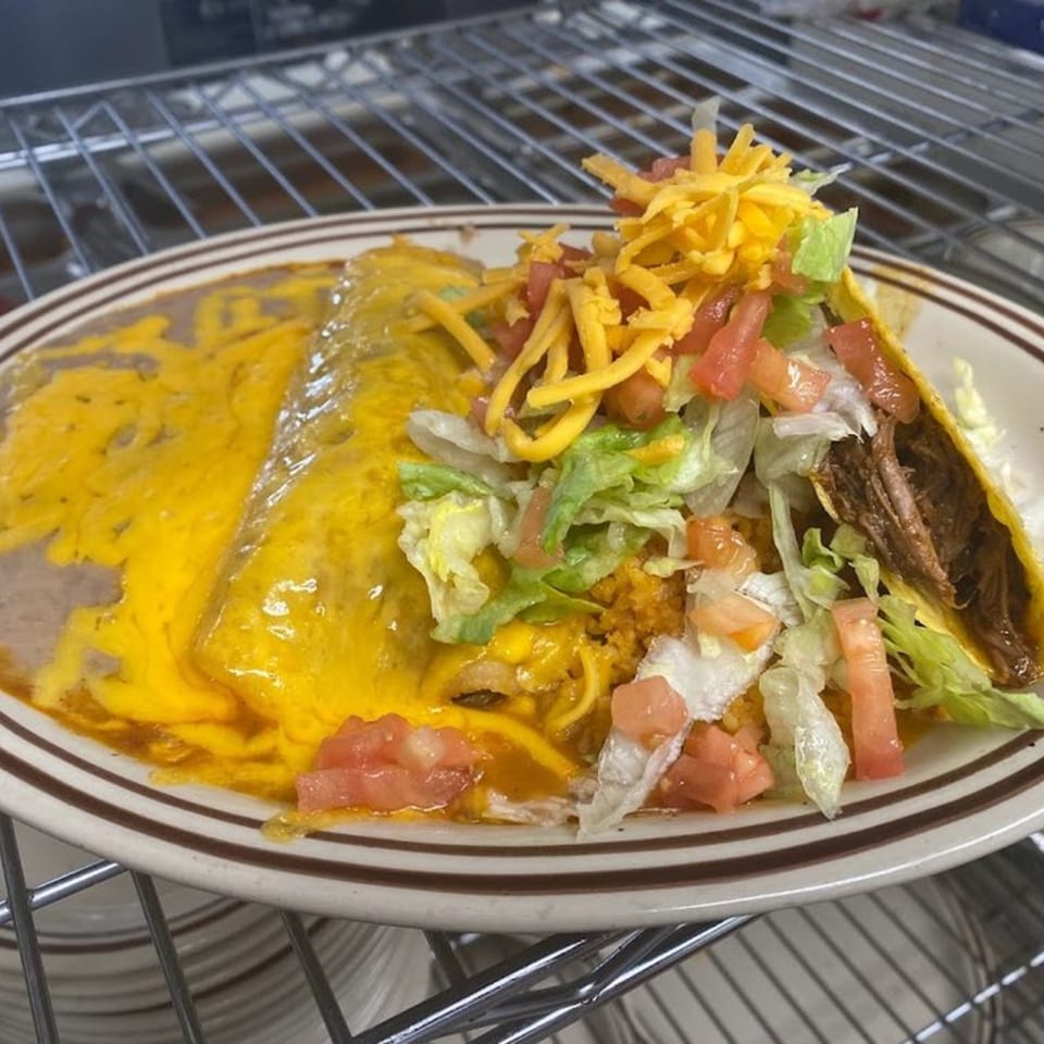 A Jalisco Mexican Grill plate with a cheese-covered burrito, a taco, rice, beans, lettuce, and tomatoes.